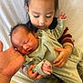 baby, bed, blanket, caring, child, closeup, clothing, comfort, face, family, hand, holding, indoor, love, newborn, person, portrait, siblings, skin, toddler