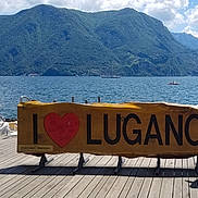 Eline participe au concours pour gagner de l'argent avec cette photo : boat, casual_clothing, child, cloud, dock, greenery, hat, holding, lake, mountain, nature, outdoor, person, relaxation, scenic, sky, sunlight, tourism, water, wooden_sign