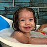 toddler, child, bathtub, bath, bubbles, wet_hair, smile, happy, face, water, skin, toy, arm, blue_tiles, indoor, bathroom, cute, playful, person, young_child