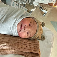 Micah is registered to the contest to win money with this photo: newborn, baby, infant, hospital, bassinet, blanket, hat, sleeping, child, cute, swaddled, face, headwear, soft, resting, indoors, medical, newborn_baby, toddler, cozy