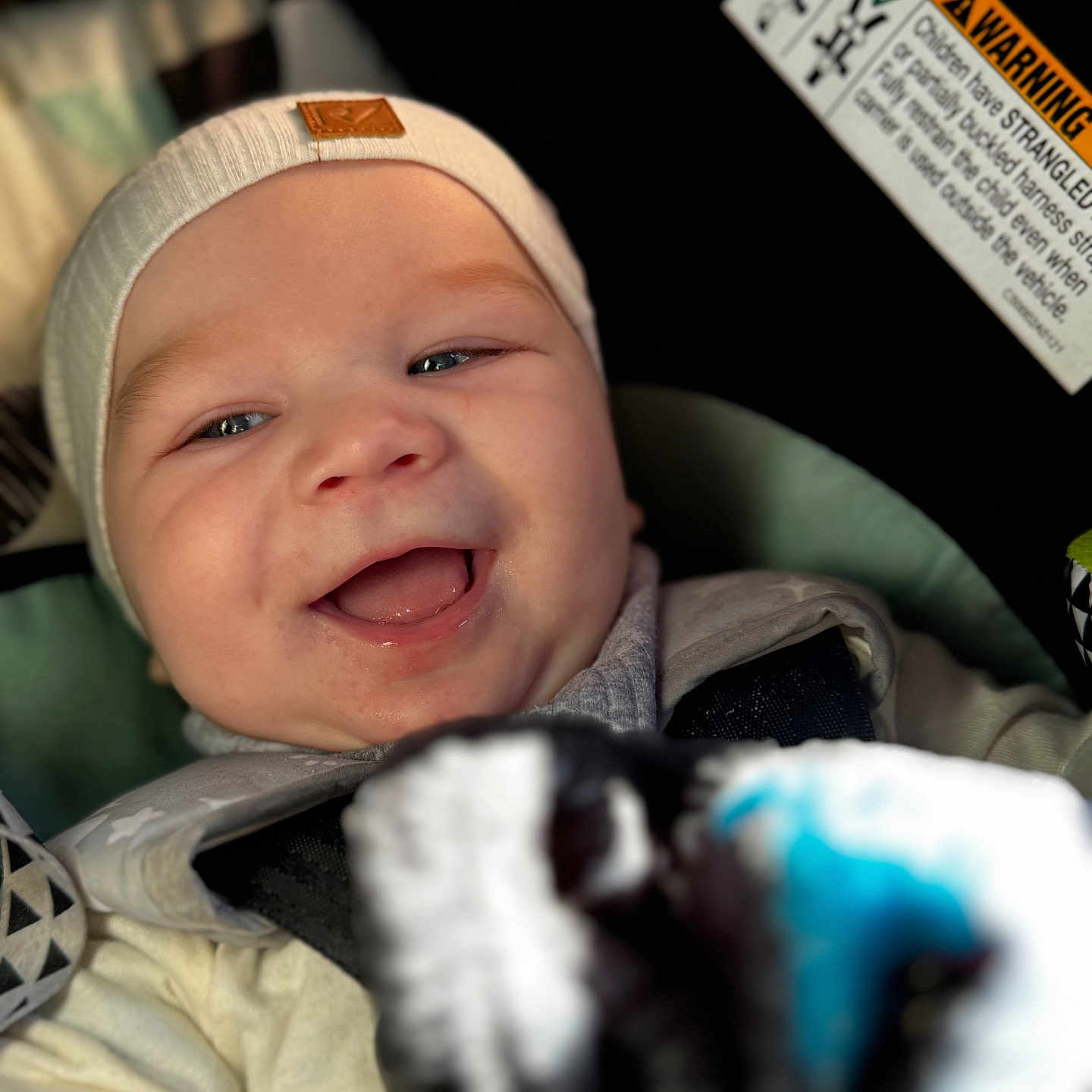 Micah is registered to the contest to win money with this photo: baby, beanie, bodypart, bonnet, cap, clothing, coat, face, finger, glove, hand, happy, hat, head, jacket, newborn, person, photography, portrait, text