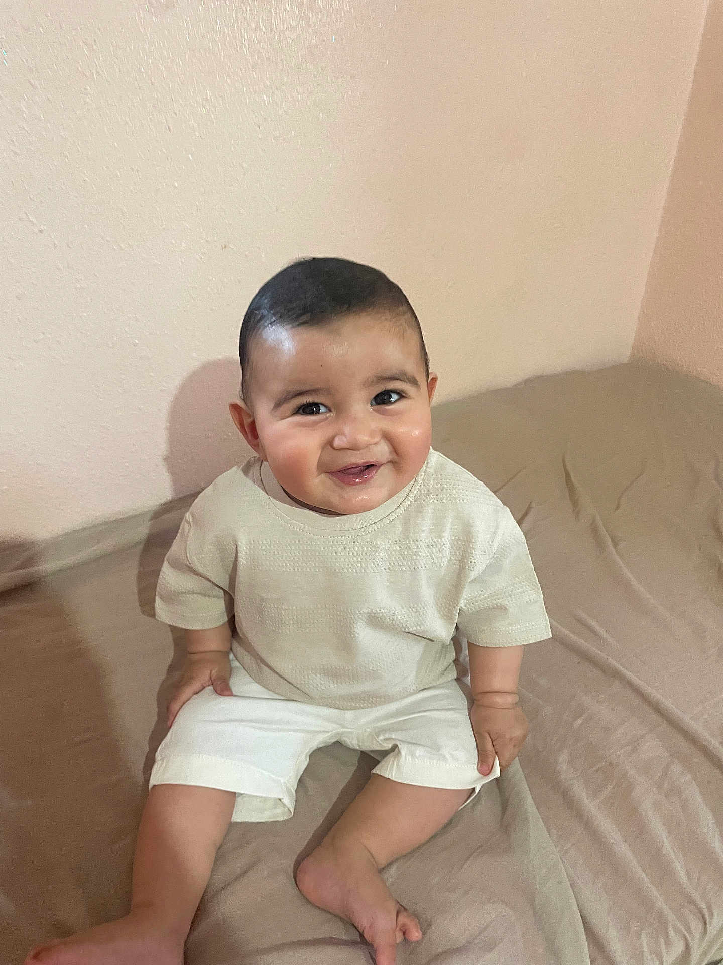 Zaïm a rejoint le concours — aidez-le/la à gagner de superbes lots ! baby, child, smiling, sitting, indoors, bed, clothing, shorts, shirt, person, face, happy, cute, infant, skin, head, foot, hand, wall, room