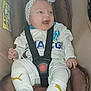 baby, car_seat, smiling, headband, white_clothing, socks, puma_logo, seatbelt, infant, happy, child, safety, cute, indoor, portrait, person, clothing, baby_accessory, seat, child_safety