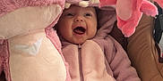 Leyah a rejoint le concours — aidez-le/la à gagner de superbes lots ! baby, child, pink, plush_toy, onesie, car_seat, smiling, happy, cute, soft_toy, stuffed_animal, indoor, cozy, infant, clothing, footwear, hood, sitting, toy, playful