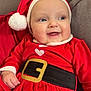 baby, child, smiling, santa_hat, christmas_outfit, red_clothing, holiday, couch, indoor, cute, portrait, festive, happy, infant, plush, seat, cozy, face, person, cheerful