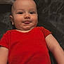 baby, infant, tongue_out, red_clothing, onesie, lying_down, cheeky, cute, skin, head, face, eyes, mouth, expression, child, person, indoors, fabric, soft, playful