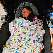Ellie joined the competition — help win amazing prizes! newborn, baby, blanket, butterfly_pattern, stroller, sleeping, child, infant, cozy, portrait, black, wooden, fabric, cute, peaceful, indoors, resting, soft, wrapped, person