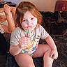 Ashley is registered to the contest to win money with this photo: child, toddler, popsicle, sitting, indoor, blanket, tshirt, person, food, snack, relaxation, hair, face, leg, hand, adult, tattoo, furniture, comfort, cozy