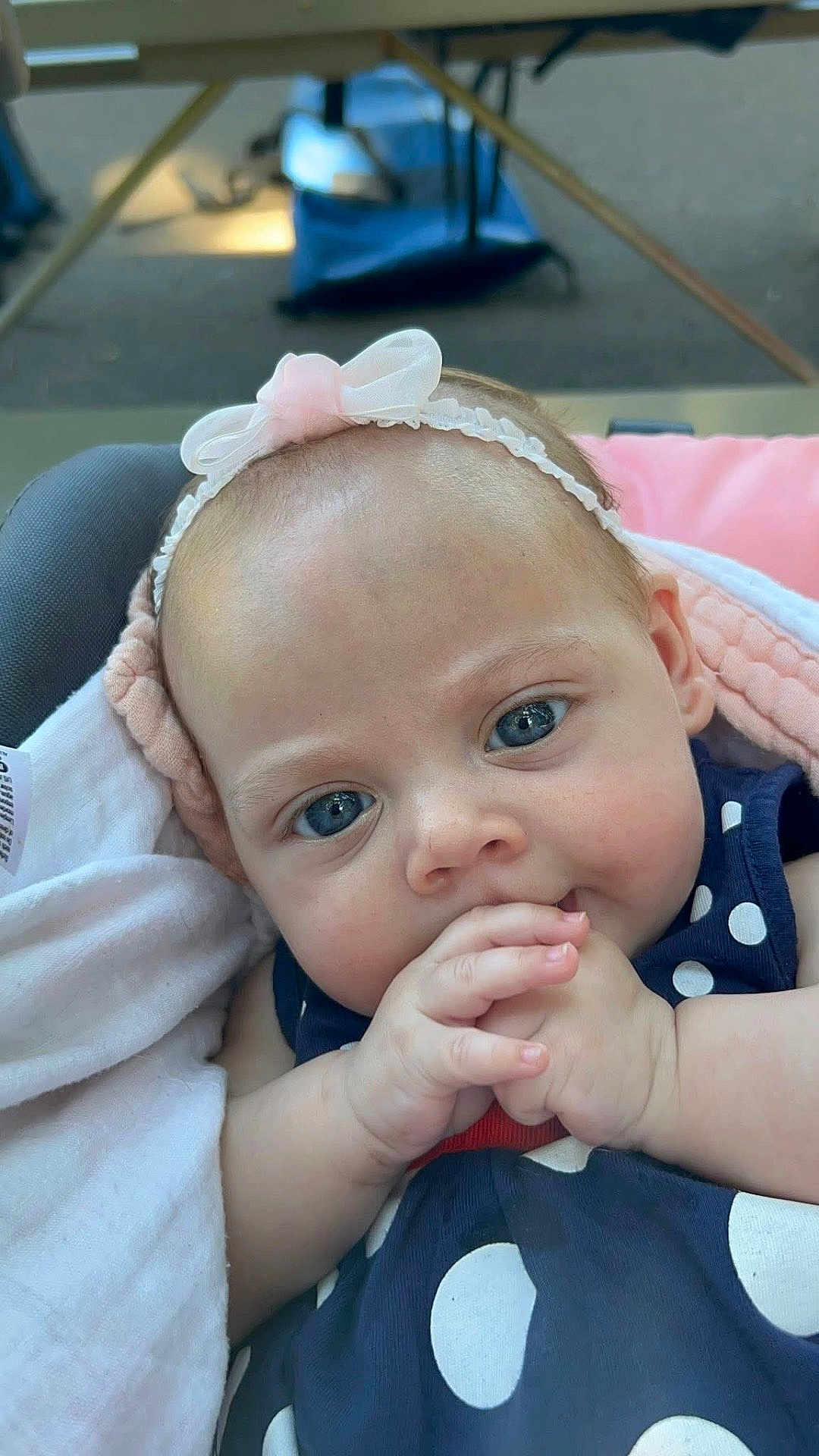 Serenity is registered to the contest to win money with this photo: baby, infant, face, blue_eyes, headband, pink_bow, hand, clothing, polka_dot, blanket, cute, portrait, close_up, child, newborn, soft_light, skin, expression, indoors, person