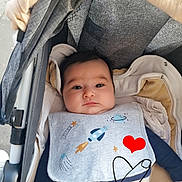 Gaya participe au concours pour gagner de l'argent avec cette photo : baby, stroller, bib, pacifier, infant, child, clothing, blanket, face, person, cute, portrait, hand_drawn_overlay, heart, outerwear, fabric, baby_clothes, relaxing, indoors, comfort