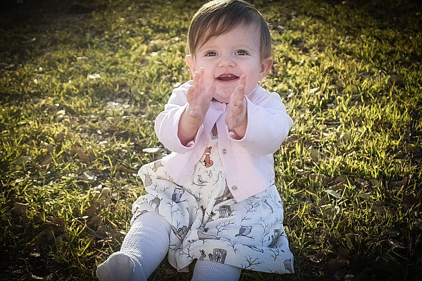 Adelynn is registered to the contest to win money with this photo: baby, cheek, child, dress, eye, grass, grass_family, happy, leaf, nose, people, person, photograph, photography, plant, sitting, skin, smile, summer, toddler
