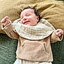 Raoul a rejoint le concours — aidez-le/la à gagner de superbes lots ! baby, smiling, infant, clothing, beige, white, raised_arms, cushion, green_background, mustard_pillow, happy, portrait, indoor, cozy, cute, child, soft_texture, fabric, person, toddler