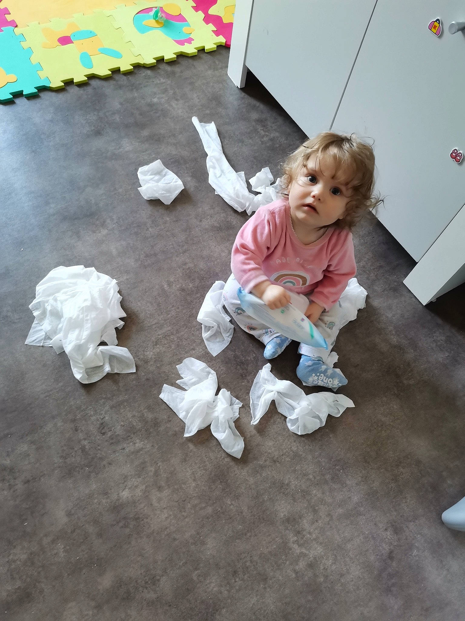 Mavie a rejoint le concours — aidez-le/la à gagner de superbes lots ! cabinetry, chest_of_drawers, child, floor, flooring, foot, fun, hardwood, human_leg, mammal, paper, paper_product, person, pink, play, room, sitting, toddler, toy, visual_arts