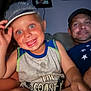 child, boy, man, cap, smile, blue_eyes, couch, indoor, family, casual_clothing, portrait, happy, people, t-shirt, arm, living_room, closeup, fun, hat, face