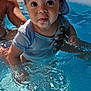 baby, child, water, pool, cap, backwards_cap, tattoo, arm, splash, summer, outdoor, blue, shirt, skin, person, young_child, cute, fun, swimming, play