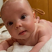 Victor a rejoint le concours — aidez-le/la à gagner de superbes lots ! adorable, arm, baby, blanket, cheeks, close_up, cute, eyes, face, gaze, hand, indoor, infant, newborn, portrait, skin, soft_lighting, sticker_heart, towel, wooden_background