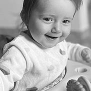 Isalyne a rejoint le concours — aidez-le/la à gagner de superbes lots ! toddler, child, baby, smiling, face, hair, pony_tail, activity_center, toy, indoor, monochrome, black_and_white, cute, happy, infant, clothing, person, closeup, playful, young