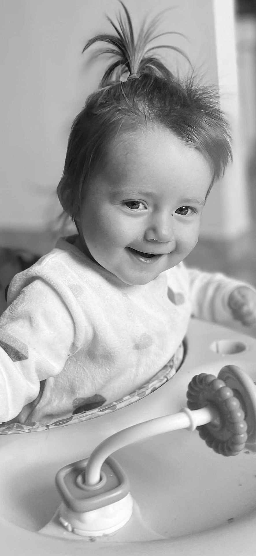 Isalyne a rejoint le concours — aidez-le/la à gagner de superbes lots ! toddler, child, baby, smiling, face, hair, pony_tail, activity_center, toy, indoor, monochrome, black_and_white, cute, happy, infant, clothing, person, closeup, playful, young