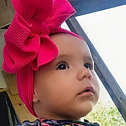 Dahlia joined the competition — help win amazing prizes! baby, child, headband, pink_bow, face, portrait, outdoor, wood, curious, expression, clothing, colorful, closeup, infant, person, young, cute, attention, natural_light, profile