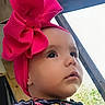 baby, child, headband, pink_bow, face, portrait, outdoor, wood, curious, expression, clothing, colorful, closeup, infant, person, young, cute, attention, natural_light, profile