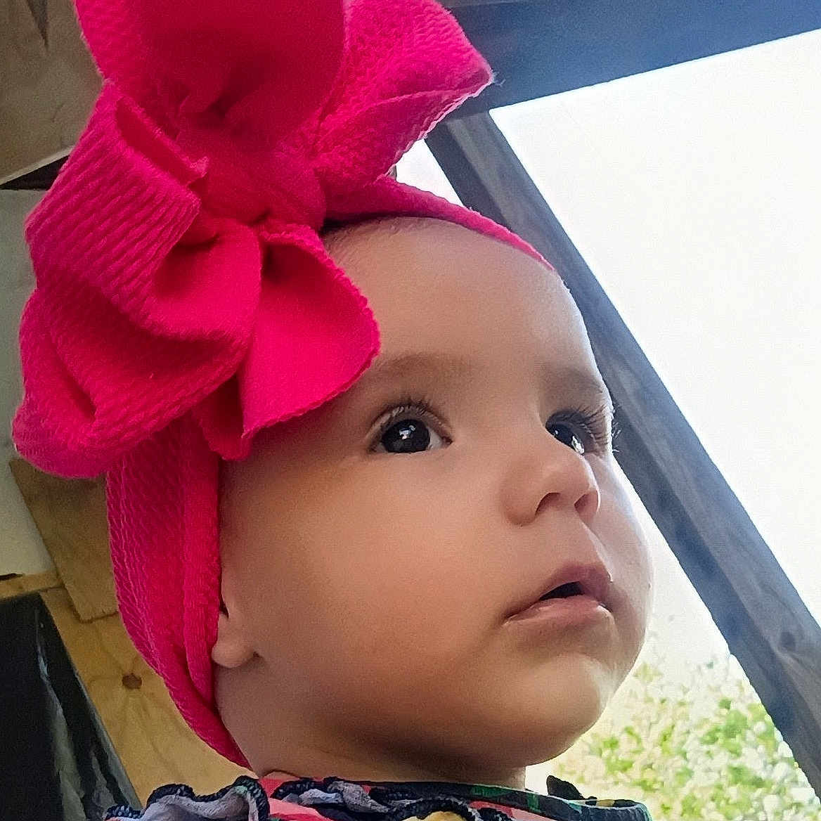 Dahlia joined the competition — help win amazing prizes! baby, child, headband, pink_bow, face, portrait, outdoor, wood, curious, expression, clothing, colorful, closeup, infant, person, young, cute, attention, natural_light, profile