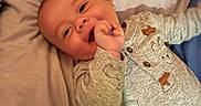 Billy G is registered to the contest to win money with this photo: baby, bear, bed, blanket, child, clothing, comfort, cute, face, hand, happy, hippo, indoor, infant, lying, onesie, pattern, portrait, smiling, soft