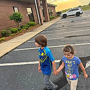 Matthias is registered to the contest to win money with this photo: child, children, boy, girl, holding_hands, parking_lot, sidewalk, building, brick_wall, car, sunset, outdoor, casual_clothing, asphalt, curb, side_view, young, walking, daylight, nature