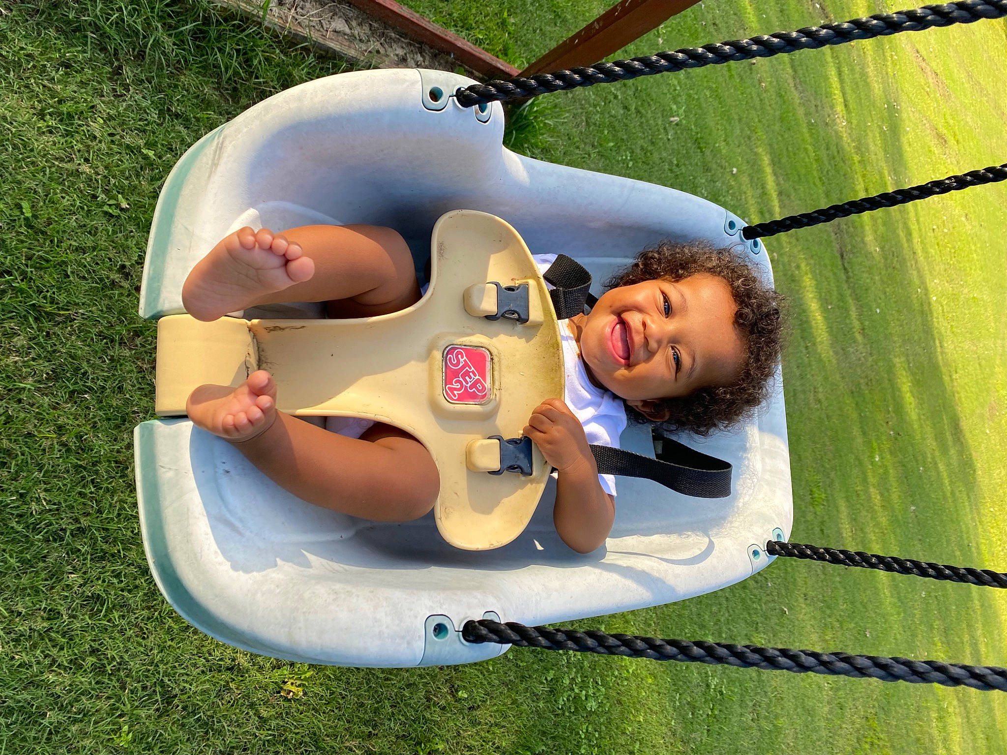 Kaida is registered to the contest to win money with this photo: baby_products, baby_toys, child, fun, games, grass, happy, inflatable, leisure, outdoor_play_equipment, people_in_nature, person, personal_protective_equipment, play, recreation, sitting, smile, toddler, toy
