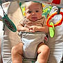 baby, infant, bouncer, toy, play, cute, child, sock, expression, tongue, indoor, seat, colorful, pattern, hands, legs, comfort, soft_light, curious, smile