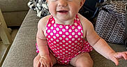 Adalynn joined the competition — help win amazing prizes! baby, child, smiling, sitting, polka_dot, pink, bow, hair_accessory, couch, indoor, happy, cute, infant, face, eyes, hand, foot, clothing, furniture, person