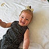 Adalynn is registered to the contest to win money with this photo: baby, child, smile, tongue, black_dress, polka_dots, hair_bow, blanket, floral_pattern, numbers, infant, cute, happy, lying_down, playful, portrait, skin, face, arm, indoors