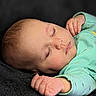 baby, sleeping, infant, peaceful, face, hand, mint_green_clothing, soft_skin, closed_eyes, portrait, child, cute, resting, young, newborn, calm, indoors, texture, black_background, small_hands