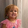 Emberleigh is registered to the contest to win money with this photo: child, smile, pink_dress, cartoon_characters, curtains, indoors, portrait, happy, toddler, girl, clothing, hair, face, person, cute, ruffled_sleeves, seated, expression, young, fashion