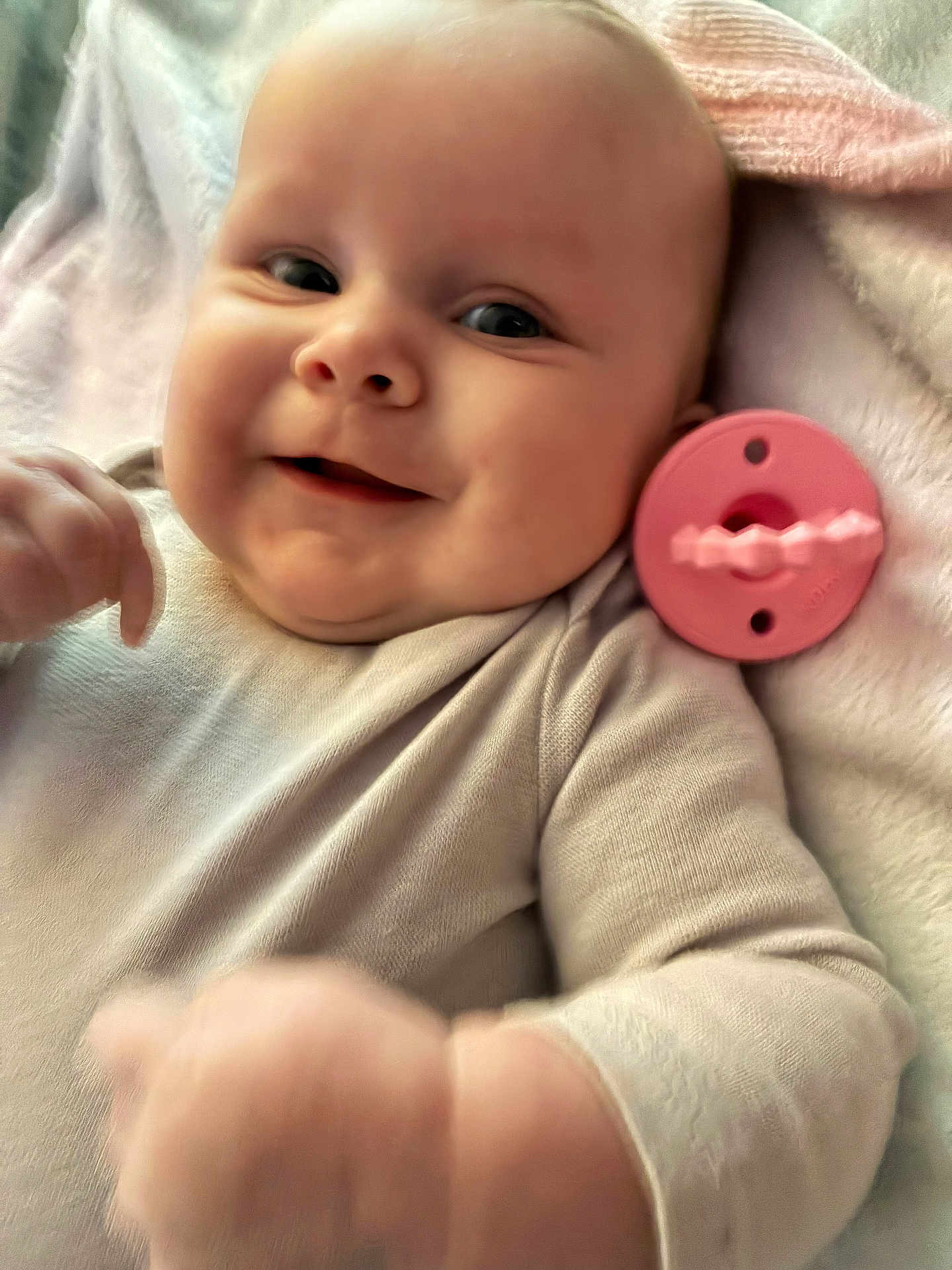 Aubriella is registered to the contest to win money with this photo: baby, smile, face, infant, clothing, blanket, toy, pink, hand, cheeks, skin, person, cute, lying_down, cozy, soft, closeup, child, happy, warm