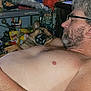 shirtless, man, glasses, sleeping, dog, pet, indoor, clutter, tools, resting, beard, closeup, relaxed, brown_dog, facial_hair, casual, napping, comfort, companion, home