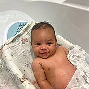 Oshea is registered to the contest to win money with this photo: arm, baby, bath, bathtub, blanket, child, comfort, cute, face, happy, head, indoors, infant, relaxing, seat, skin, smiling, towel, wash, water