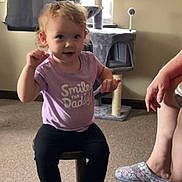 Hadleigh is registered to the contest to win money with this photo: brown_shoes, carpet, casual_clothing, cat_tree, child, curly_hair, curtains, cute, happy, home, indoor, legs, living_room, person, purple_shirt, slippers, smile, toddler, window, wooden_stool