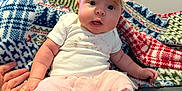 Karlina M Yokley is registered to the contest to win money with this photo: baby, child, infant, tutu, headband, pink_clothing, hand_holding, blanket, patterned_blanket, sitting, footwear, white_shoes, indoor, person, cute, expression, face, wide_eyes, soft_lighting, home