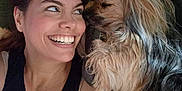 Benji is registered to the contest to win money with this photo: affection, black_clothing, blanket, closeup, couch, dog, eyes, face, friendship, furry, hair, happy, indoor, lying_down, nose, nostrils, pet, skin, smiling, woman