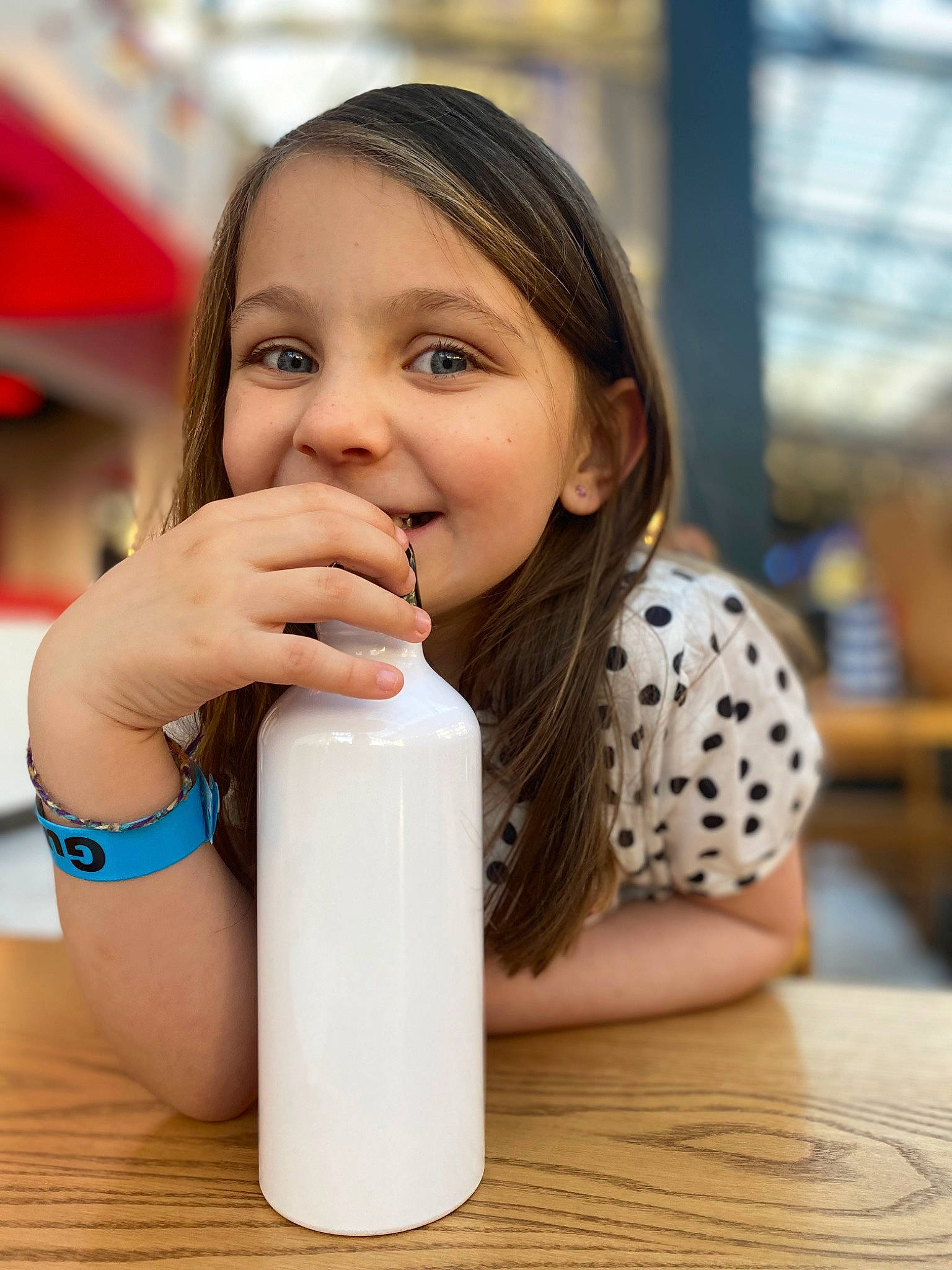 Emerie joined the competition — help win amazing prizes! bottle, child, drink, drinking, drinkware, eyelash, facial_expression, finger, happy, joy, lip, liquid, nail, neck, person, plastic_bottle, skin, smile, table, thumb