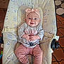 animal_print, apparel, baby, baby_seat, child, clothing, cushion, cute, floor, footwear, happy, headband, indoor, infant, person, pink, portrait, sitting, smiling, young