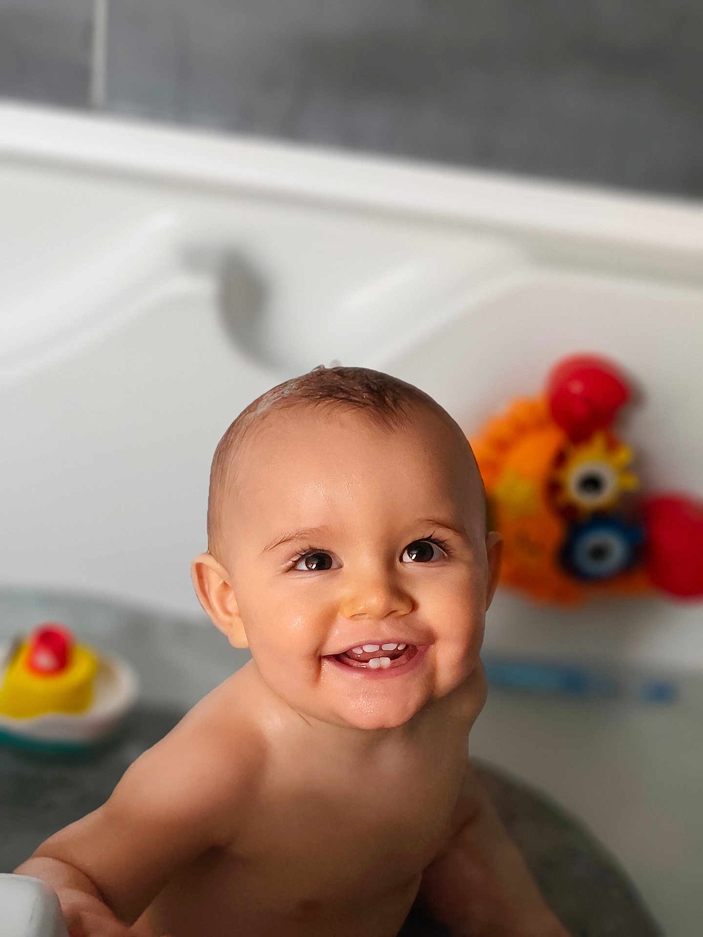 Elio participe au concours pour gagner de l'argent avec cette photo : baby, infant, smiling, smile, face, eyes, teeth, bath, bathtub, water, toy, rubber_duck, colorful_toy, wet_skin, cute, happy, portrait, play, bathroom, child