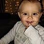 Elio participe au concours pour gagner de l'argent avec cette photo : baby, infant, smile, teething, finger_in_mouth, onesie, long_sleeve, big_eyes, portrait, close_up, indoor, cozy, holiday_lights, bokeh, warm_lighting, cute, happy, sparkle, festive, family