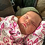 baby, newborn, sleeping, onesie, heart_pattern, cozy, closeup, face, infant, child, soft, cushion, blanket, cute, peaceful, indoors, portrait, resting, young, warm