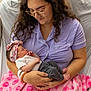 woman, newborn, baby, pajamas, glasses, hospital, blanket, pink, bed, bedroom, bracelet, headband, sleeping, holding, person, indoor, curly_hair, family, mother, child