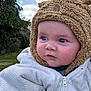 Mylann participe au concours pour gagner de l'argent avec cette photo : baby, child, face, blue_eyes, hat, fuzzy_hat, white_jacket, outdoor, grass, tree, cloudy_sky, closeup, portrait, cute, warm_clothing, person, infant, nature, winter_wear, hand