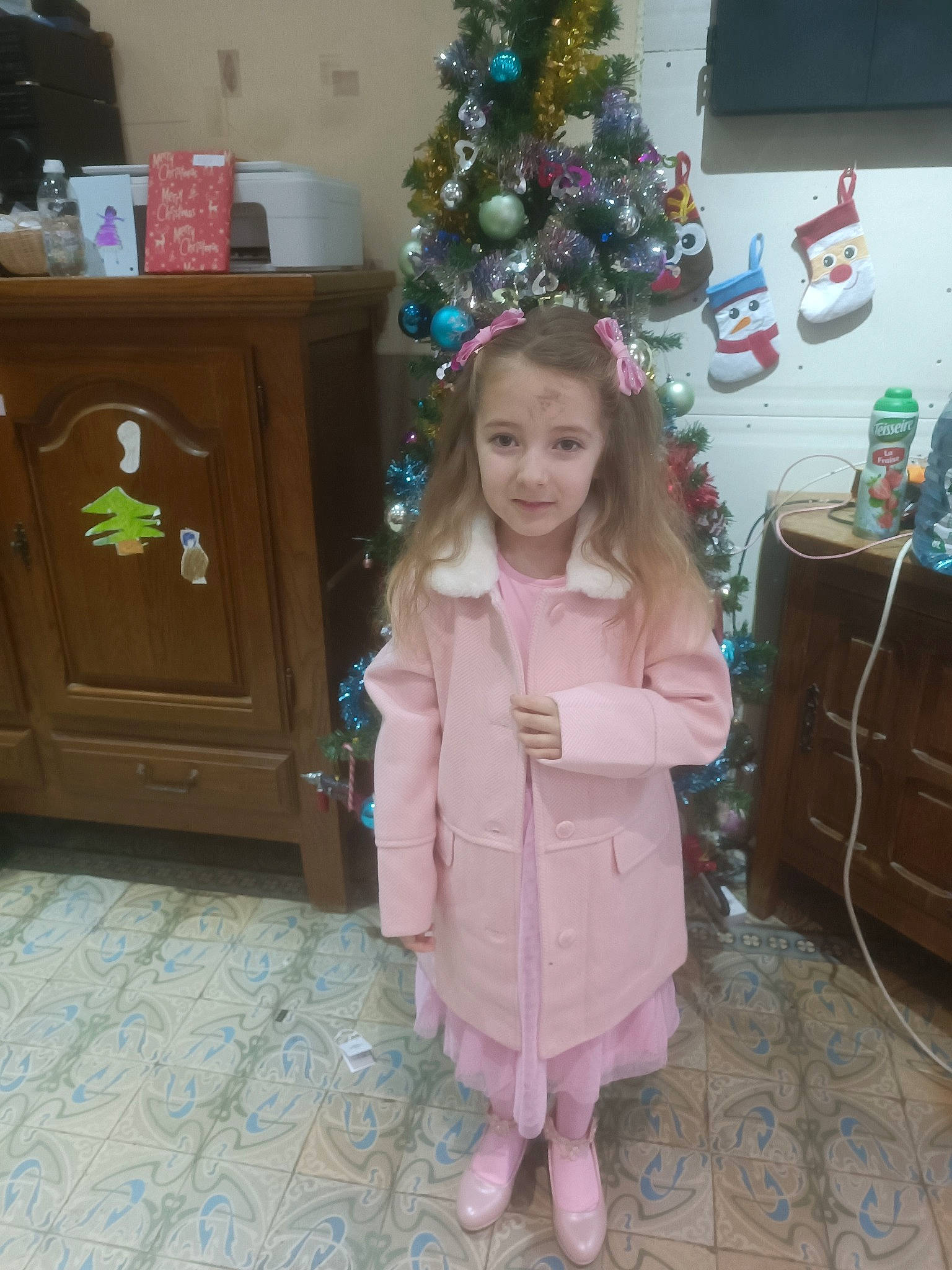 Eden participe au concours pour gagner de l'argent avec cette photo : baby_toddler_clothing, cabinetry, child, christmas, christmas_decoration, christmas_eve, christmas_ornament, christmas_tree, drawer, event, flooring, fun, holiday, holiday_ornament, joy, person, plant, room, smile, toddler