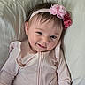 baby, infant, child, smile, headband, pink, flower, clothing, pillow, cute, portrait, happy, face, person, indoors, young, soft, skin, hair, sitting