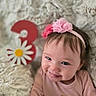 baby, girl, smiling, headband, flower, pink, number_three, daisy, fluffy_blanket, soft_texture, celebration, cute, portrait, closeup, happy, infant, child, indoor, cozy, toddler