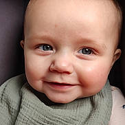 Asher is registered to the contest to win money with this photo: baby, child, smiling, face, blue_eyes, bib, clothing, portrait, close_up, infant, cute, happy, skin, hair, young, one_person, indoor, soft_light, expression, baby_bib
